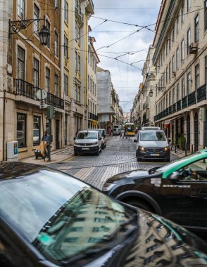 Lizbon, Portekiz - 10.04.2019: başkentin dar sokaklarında ulaşım, ortadaki cadde manzarası, her iki taraftaki binalar.