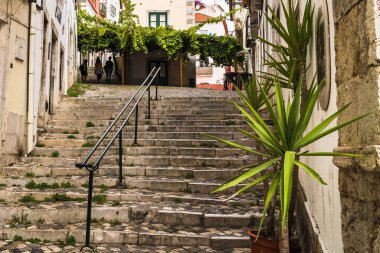 Lizbon 'un eski bir kasabasında, tepeye çıkan basamakları olan küçük bir yaya sokağı..