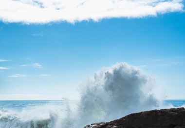 Atlantik Okyanusu dalgaları kayalık kıyılara karşı beyaz köpüğü kamçılıyor, Ericeira, Portekiz.