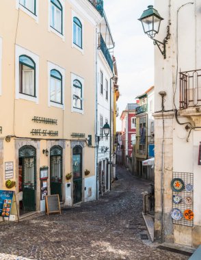 Coimbra / Portekiz - 10 / 02 / 2019: Caddenin her iki tarafında taşlarla, dükkanlarla ve kafelerle döşenmiş dar bir Coimbra caddesi.