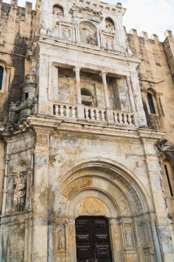 Coimbra / Portugal - 10/02/2019: Romanesque cathedral, ornate facade and doors of the old cathedral. clipart