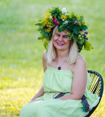 Yaz gündönümü çelengi, el yapımı, doğada oturan kadın..