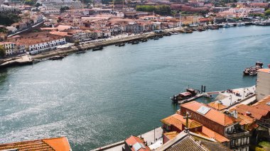 Porto, Portekiz - 10.01.2019: Douro Nehri 'ne bakan Porto şehri manzarası. Güneşli bulutlu bir gün. Kırmızı kiremitli çatılara bak.