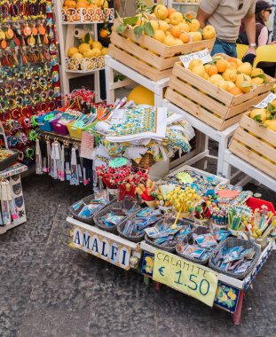 Amalfi, İtalya - 27 Nisan 2025: Kapısı sokakta bulunan küçük bir dükkan mallarını turistlere gösteriyor. Amalfi Sahili, İtalya.