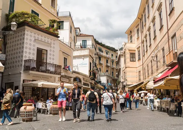 Amalfi, İtalya - 27 Nisan 2025: Amalfi 'nin tarihi merkezinde birçok dükkan ve yiyecek yeri olan ana yaya sokağı..