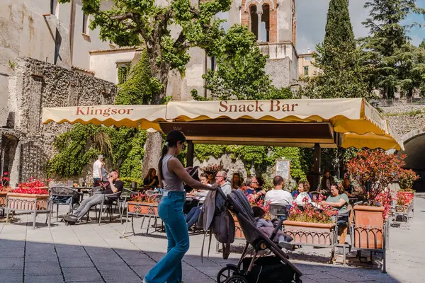 Ravello, İtalya - 27 Nisan 2025: Ravello şehrinin ana meydanında ilkbaharda katedral ve Duomo kilisesi yakınlarında turistler. Villa Rufolo 'nun yanında..