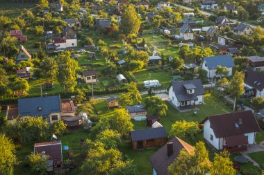 Letonya 'nın yeşil doğasına kuş bakışı bakış açısı, çayırlar, ağaçlar, ormanlar, tarlalar, Jelgava bölgesindeki evler. Güneşli hava, akşam.