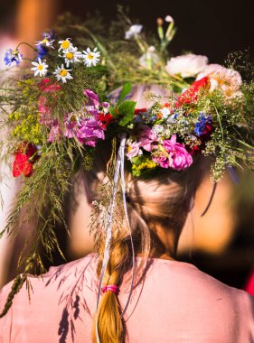 Yaz gündönümü çelengi ve bahçe çiçekleri sarı saçlı ve saçı örgülü bir kız için, el yapımı, odak noktasında bireysel parçalar, yaz günü
