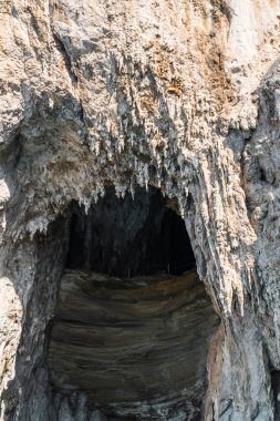 Capri, İtalya - 04.29.2025: İçinde mağara deliği olan beyaz bir dağ sırası.