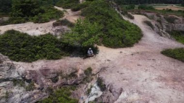 Terk edilmiş maden göletinin tepesinde İHA uçuran bir adamın hava görüntüsü. 