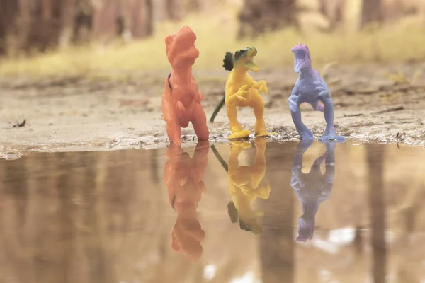 dinosaur toys illustrating loitering around the lake