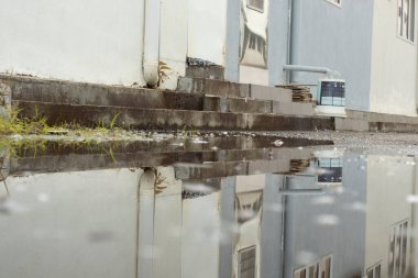 stagnant pool of water scene after rain at the suburb asphalt street 