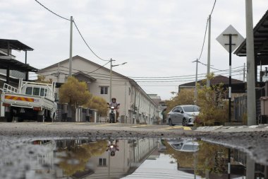 Perak,Malaysia. December 30,2022: Scene of the stagnant pool of water after rain around the suburb asphalt street at Kg Koh Market Area. 