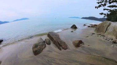 walking along huge boulders laying by the seaside.