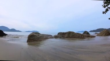 walking along huge boulders laying by the seaside.