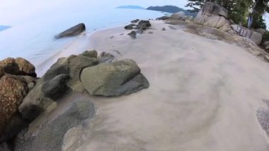 walking along huge boulders laying by the seaside.