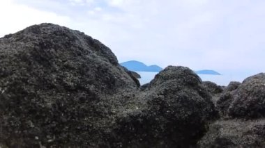 walking along huge boulders laying by the seaside.