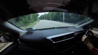 Perak, Malaysia. January 15,2023: Footage of the asphalt street in the countryside while driving in the interior and looking out the car front screen window along the Teluk Senangin to Lumut highway.