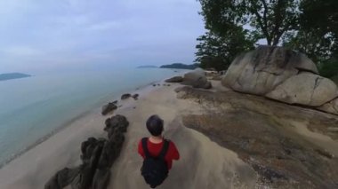 walking along huge boulders laying by the seaside.
