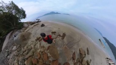 walking along huge boulders laying by the seaside.