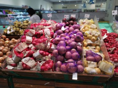 Perak, Malaysia. February 22, 2023 : Varieties of onions and garlic on the shelves for sale and display at Aeon Sri Manjung Supermarket. 