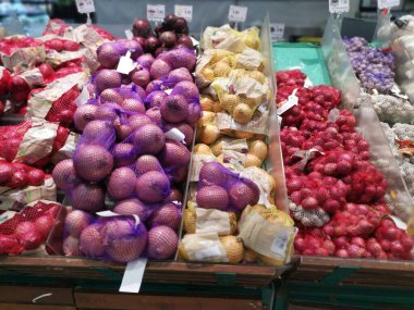 Perak, Malaysia. February 22, 2023 : Varieties of onions and garlic on the shelves for sale and display at Aeon Sri Manjung Supermarket. 