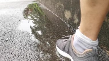 Sokaktaki su birikintisinin üzerinde yürüyorum.