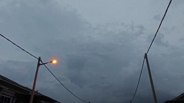 Karanlık çöktüğünde karanlık bulutlu gökyüzü yerleşim yerinin sokağında 