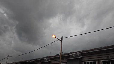 Karanlık çöktüğünde karanlık bulutlu gökyüzü yerleşim yerinin sokağında 