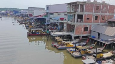 Perak, Malezya. 21 Haziran 2023: Kuala Sepetang, Taiping 'deki kıyı mangrov bölgesi boyunca yer alan balıkçı köyü çevresindeki evler ve faaliyetler.