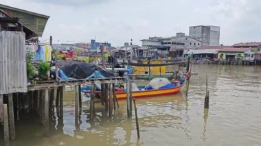 Perak, Malezya. 21 Haziran 2023: Kuala Sepetang, Taiping 'deki kıyı mangrov bölgesi boyunca yer alan balıkçı köyü çevresindeki evler ve faaliyetler.