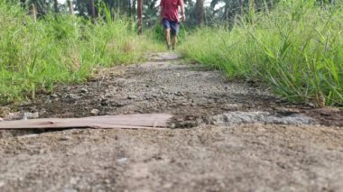 Erkek model kırsal yolda tek başına yürüyor.