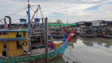 Perak, Malezya. 13 Temmuz 2023: Bagan Datok, Sungai Burung 'daki bataklık sahilindeki köy limanı boyunca kalabalık balıkçı tekneleri sahnesi.