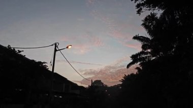 Sokakta güzel kırmızı günbatımı gökyüzüne bakarken