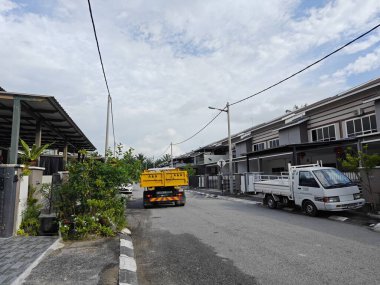 Perak, Malezya. 23 Ağustos 2023: Sarı bir arka fırlatma kamyonu Taman Mas1, Kg Koh 'un sakin yerleşim caddesi boyunca park etmiş..