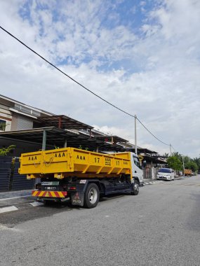 Perak, Malezya. 23 Ağustos 2023: Sarı bir arka fırlatma kamyonu Taman Mas1, Kg Koh 'un sakin yerleşim caddesi boyunca park etmiş..