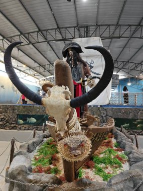 Perak, Malezya. 23 Ağustos 2023: Karayip Korsanları filmindeki gibi giyinen manken, Sg Burung 'daki Kapalı Balık Kuaryumu' nda teknenin önünde bufalo kafatası vardı..