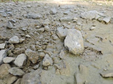 Yol boyunca taşlarla bırakılmış kurumuş su birikintisi. 