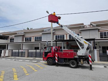 Perak, Malezya. 2 Eylül 2023: İşçilerin sokak lambası direğini Taman Mas 1 caddesindeki Arkadaki Merdiven Kamyonu ile değiştirdikleri açık hava sahnesi.