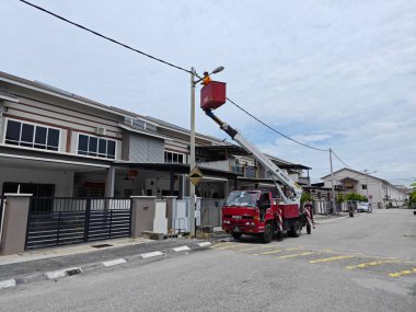 Perak, Malezya. 2 Eylül 2023: İşçilerin sokak lambası direğini Taman Mas 1 caddesindeki Arkadaki Merdiven Kamyonu ile değiştirdikleri açık hava sahnesi.