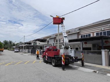 Perak, Malezya. 2 Eylül 2023: İşçilerin sokak lambası direğini Taman Mas 1 caddesindeki Arkadaki Merdiven Kamyonu ile değiştirdikleri açık hava sahnesi.