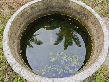 Silindirik beton kuyunun yüzeyine bakıyorum..