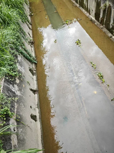 Şehir caddesinde açık beton drenaj sistemi var..