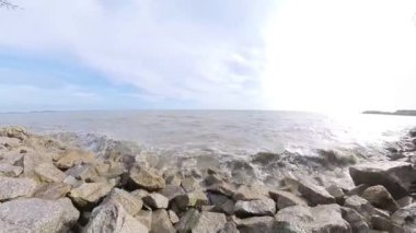 Kayalık sahile vuran deniz suyunun yüksek akıntısının görüntüleri.