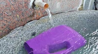 Su dolu küvet ve birkaç renkli su kepçesi.. 