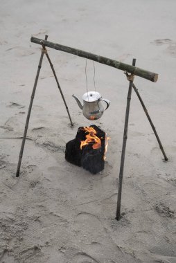 Sahildeki kamp ateşinde kaynar su ısıtıcısı..