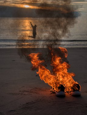 Sahilde alevler içinde bırakılmış bir çift spor ayakkabı.