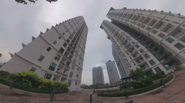 Ön plandaki gökdelen binası ile kasvetli gökyüzü arka planına bakıyorum..