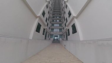 Ön plandaki gökdelen binası ile kasvetli gökyüzü arka planına bakıyorum..