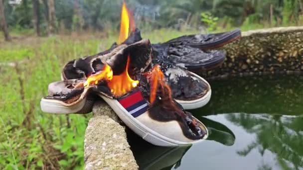旧鞋子被火堆扔在圆柱形混凝土井边 302614172 — 图库视频影像